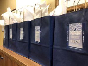A close up scaled shot of navy gift bags with white tissue paper - Traditions at Camargo Sticker on each bag
