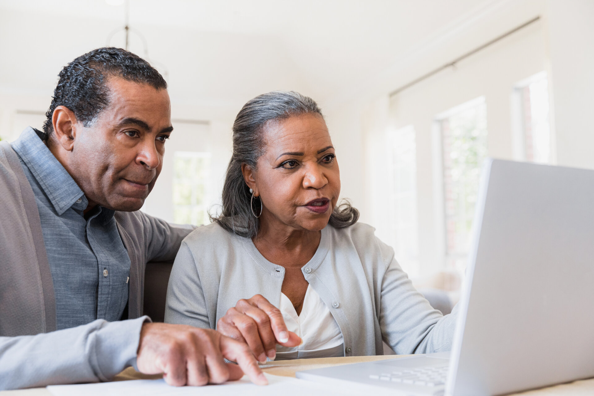 Senior man and senior woman inquiring about senior living services at Traditions at Camargo on a laptop